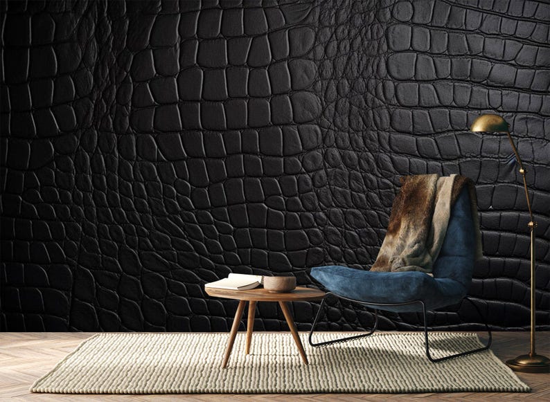 May include: A black crocodile-textured wall covering dominates the scene, complemented by a blue armchair with a brown and beige throw. A small wooden table and a floor lamp add to the room's decor. A neutral-toned rug completes the setting.