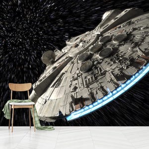 Può includere: Illustrazione dettagliata dell'astronave Millennium Falcon su uno sfondo di campo stellare. La nave è grigia con dettagli intricati e un bordo blu brillante. Una sedia di legno con un panno verde in primo piano.