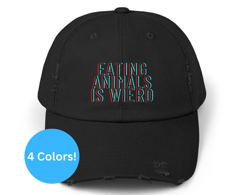 May include: Black distressed baseball cap with the text "EATING ANIMALS IS WIRED" in a 3D effect. The text is in red and blue. A blue circle with the text "4 Colors!" is in the lower left.
