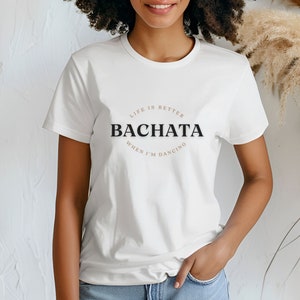 May include: White t-shirt with a black and brown graphic that says "Life is better when I'm dancing Bachata".