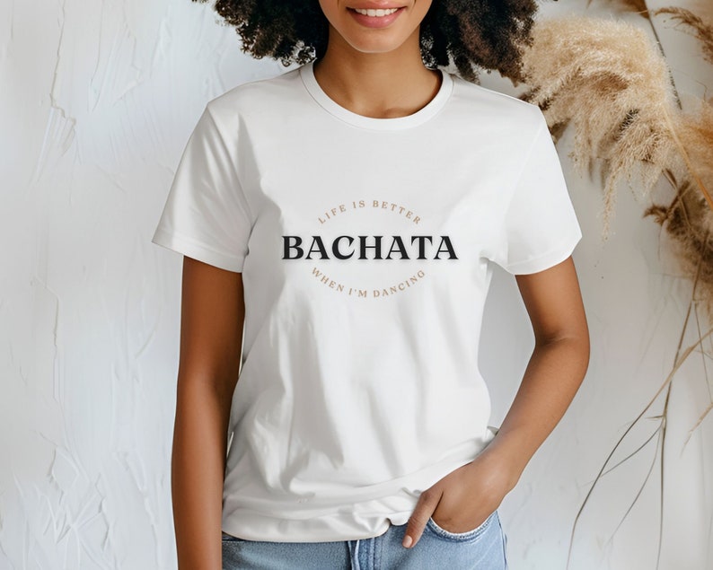 May include: White t-shirt with a black and brown graphic that says "Life is better when I'm dancing Bachata".