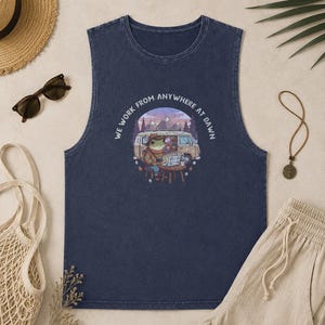 Sleeveless navy shirt with a frog working on a laptop next to a van.