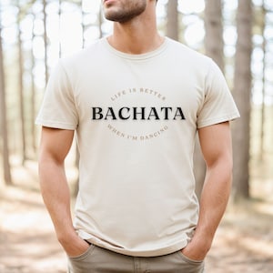 May include: A beige t-shirt with the text "Life is better when I'm dancing Bachata" printed on the front.