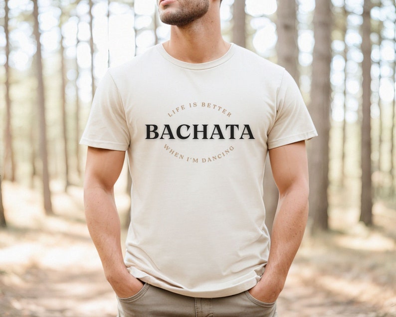 May include: A beige t-shirt with the text "Life is better when I'm dancing Bachata" printed on the front.