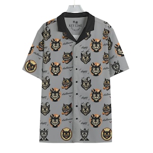 May include: A gray short-sleeved button-up shirt with a black collar and a repeating pattern of black cats with the text "Happy Halloween" and "Key Lime Sublime" on the collar.