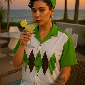 May include: A retro-style button-up shirt with a white base, green collar and sleeves, and a brown and green diamond pattern. The shirt is paired with a green headscarf. A cocktail with a lime garnish is held in a martini glass.