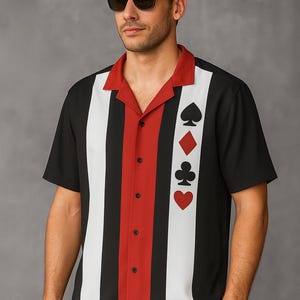May include: Black, white, and red short-sleeve shirt with a bowling shirt style. The shirt features vertical stripes and playing card suit symbols: spades, diamonds, clubs, and hearts. The collar is red, and the shirt has black buttons.