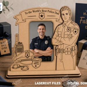 Puede incluir: Un marco de fotos de madera cortado con láser con una abertura rectangular central, una ilustración grabada de un oficial de policía, una gorra, una radio, esposas y una insignia. El estandarte superior dice To the World's Best Police Dad.
