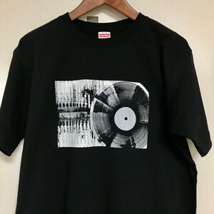May include: Black t-shirt with a graphic of a vinyl record and a sound wave pattern. The text "Limited Edition" is printed on the tag.