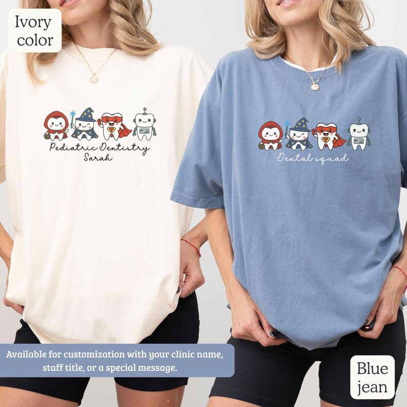 K&ouml;nnte beinhalten: Zwei T-Shirts, eines in Elfenbein und eines in Jeansblau, mit einem Cartoon-Design einer Zahnarztgruppe. Das elfenbeinfarbene Shirt tr&auml;gt den Text "Pediatric Dentistry Sarah", w&auml;hrend das Jeansblau-Shirt "Dental squad" sagt. Beide Shirts sind anpassbar.