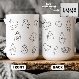 Puede incluir: Taza de cerámica blanca con asa y borde negros, con dibujos lineales negros de gallinas, huevos y plumas. La taza tiene las palabras "FRONT" y "BACK" impresas. También se muestra el nombre "EMMA".