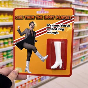 Puede incluir: Un juego de novedad con el texto "GIVE THEM THE BOOT PLAYSET" sobre un fondo naranja. La imagen presenta a una mujer con traje y botas, y una bota blanca en una funda de plástico. También está presente el texto "It's time. You've waited long enough."