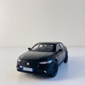 Puede incluir: Modelo de coche negro de fundición a presión con una matrícula suiza que dice "D-998XN".