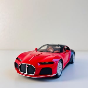 May include: A red and black toy car model of a Bugatti.