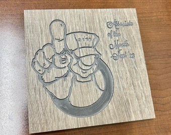 May include: A wooden plaque with a black and white illustration of a cartoon character giving a thumbs up. The plaque has the text "Associate of the Month - Sept 23".