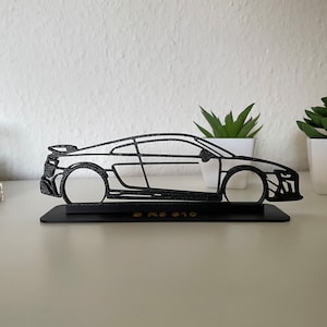 May include: Black metal silhouette of an Audi R8 car on a black base with the text "R8 GT0" in gold lettering.