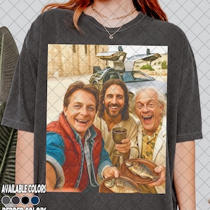 May include: Dark gray t-shirt featuring a humorous image of three people, one holding a cup and two holding plates with fish, with a DeLorean car in the background. The text "AVAILABLE COLORS" and "PEPPER COLORS" is at the bottom.