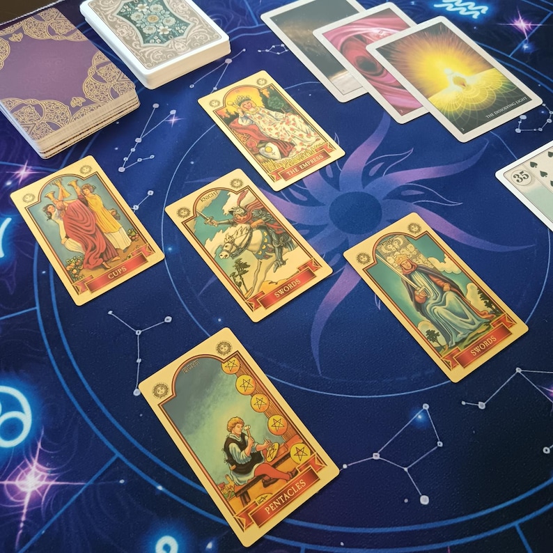 a tarot card spread on a blue and purple background with stars and celestial elements.