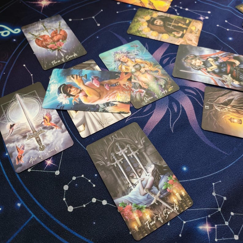 a collection of tarot cards spread out on a starry night sky background.