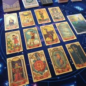 a collection of tarot cards arranged on a table, with various illustrations and text.