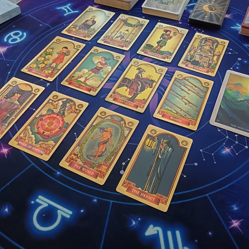 a collection of tarot cards arranged on a blue background with a starry night sky pattern.