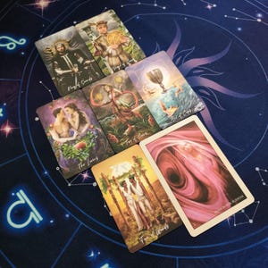 a collection of tarot cards spread out on a starry night sky background.
