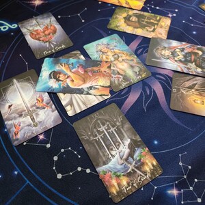 a collection of tarot cards spread out on a starry night sky background.