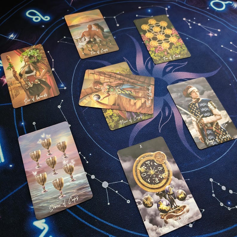 a collection of seven tarot cards arranged on a starry night sky background.