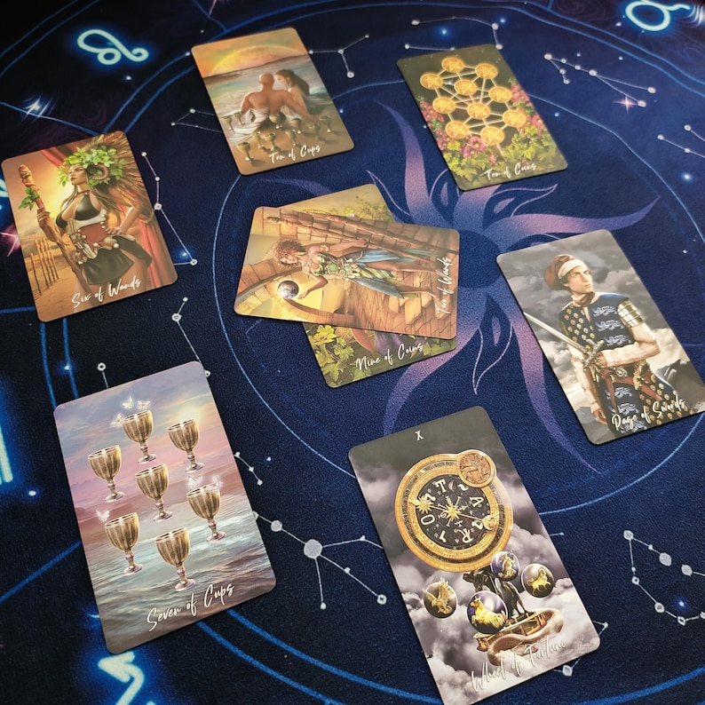 a collection of seven tarot cards arranged on a starry night sky background.