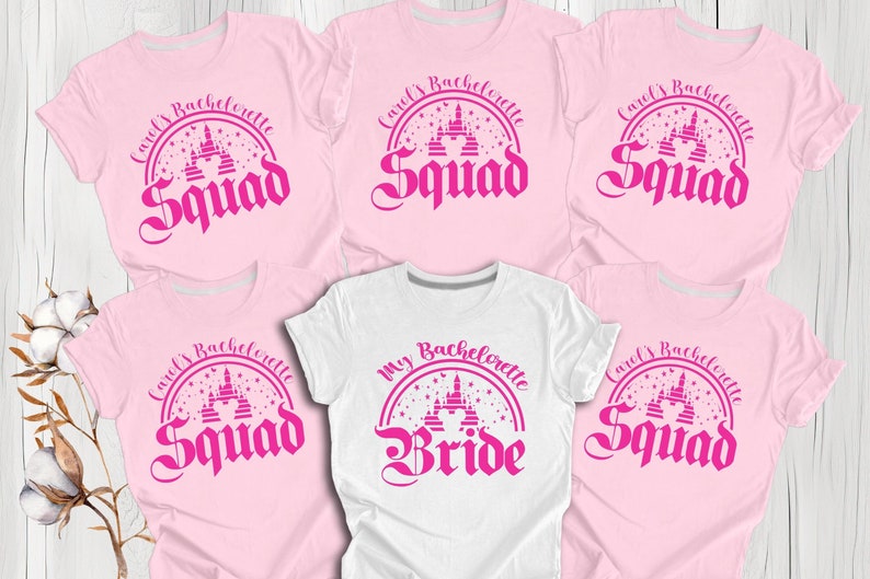 May include: Five pink t-shirts with a pink castle graphic and the text "Carol's Bachelorette Squad" and one white t-shirt with a pink castle graphic and the text "My Bachelorette Bride".