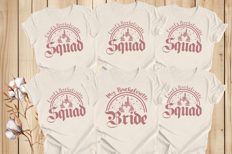 May include: Six white t-shirts with pink text and a pink graphic of a castle. The text on the shirts reads "Carol's Bachelorette Squad" and "My Bachelorette Bride".