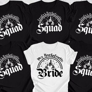 May include: Five black t-shirts with white text and a graphic of a castle. One white t-shirt with black text and a graphic of a castle. The text on the black shirts reads "Kayla's Bachelorette Squad". The text on the white shirt reads "My Bachelorette Bride".