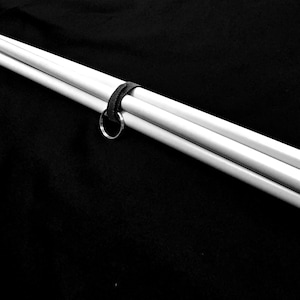 May include: A set of three white telescoping poles with a black strap and a silver ring.