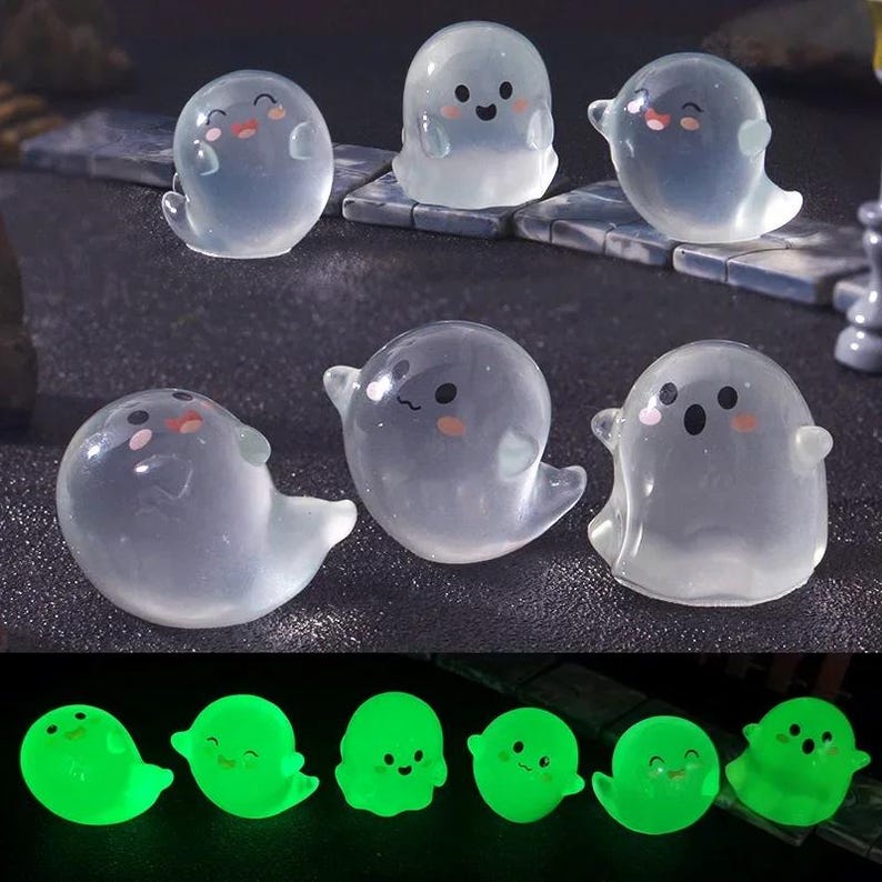 Pode incluir: Uma cole&ccedil;&atilde;o de figuras de fantasmas transl&uacute;cidos com rostos sorridentes e bochechas rosadas. Os fantasmas t&ecirc;m uma forma arredondada com uma cauda fluida. Abaixo, uma fileira de figuras de fantasmas verdes brilhantes &eacute; exibida.