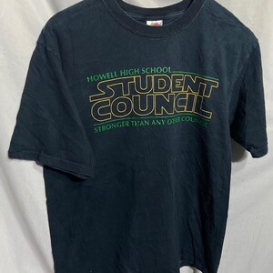 May include: Black t-shirt with a green and yellow graphic that reads "Howell High School Student Council" and "Stronger Than Any Other Council".