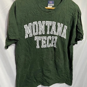 May include: Green t-shirt with a white "Montana Tech" logo printed on the front.