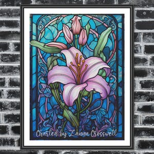 Può includere: Stampa artistica incorniciata con un'illustrazione dettagliata di un giglio rosa con foglie e boccioli verdi, su uno sfondo in stile vetrata colorata nei toni del blu e del viola. Il testo "Charted by Lanna Crosswell" è in basso.