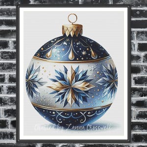 May include: A framed print of a Christmas ornament. The ornament is a blue and white sphere with gold accents and snowflake designs. The text "Charted by Zanna Crosswell" is at the bottom.