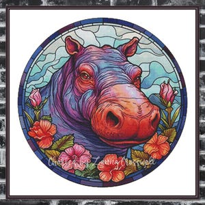 Può includere: Un'opera d'arte colorata in stile vetrata raffigurante la testa di un ippopotamo. L'ippopotamo è raffigurato con sfumature di viola, blu e arancione, circondato da fiori rosa e rossi. L'opera è circolare e incorniciata.