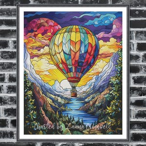 Può includere: Una stampa artistica incorniciata raffigurante una mongolfiera colorata sopra un paesaggio montano. Il pallone è un mosaico di rosso, giallo, blu e verde. L'opera d'arte include il testo "Charted by Zanna Crosswell".
