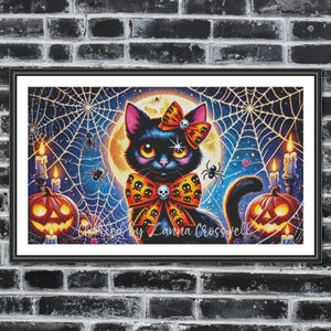 Op de afbeelding: Een ingelijst Halloween-kunstwerk met een zwarte kat met een strik en een vlinderdas versierd met schedels. De kat staat tegen een achtergrond van een volle maan, spinnenwebben, pompoenen en kaarsen. Het kunstwerk is gesigneerd "Created by Lanna Crosswell".