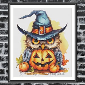 Puede incluir: Un búho azul con un sombrero de bruja y sosteniendo una calabaza tallada. El búho está rodeado de hojas de otoño y dos pequeñas calabazas. El texto "Charted by Laura Crosswell" está en la parte inferior de la imagen.
