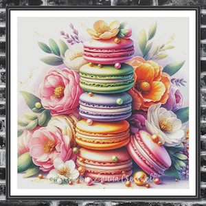 May include: A stack of colorful macarons with pastel pink, green, purple, and orange frosting, surrounded by pink, white, and orange flowers. The macarons are decorated with white pearls and are arranged in a tower.