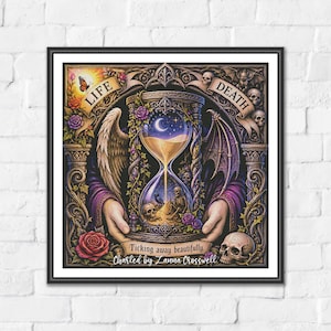 May include: A framed square art print featuring an ornate hourglass held by hands, with an angel wing on the left and a bat wing on the right. The text reads LIFE, DEATH, Ticking away beautifully, and Charted by Lanna Crosswell, with skulls and roses.