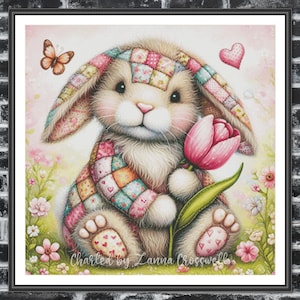 May include: A patchwork bunny holding a pink tulip with a butterfly flying above. The bunny is wearing a colorful patchwork scarf and has a heart-shaped patch on its foot. The background is a soft pink and green with flowers.