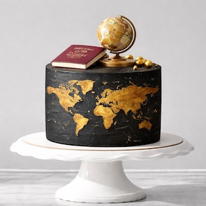 Può includere: Torta nera decorata con un design a mappa del mondo dorata, sormontata da un mappamondo, un libro bordeaux e sfere dorate. La torta è su un supporto bianco a più livelli, perfetto per un evento a tema viaggio.