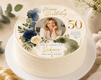 May include: A round white frosted cake featuring a personalized edible topper with a circular photograph of a person, the text Happy Birthday, the number 50, and the name Sabine, decorated with navy blue and cream roses and green foliage accents.