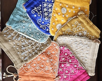 May include: A collection of nine drawstring bags with different colored fabrics and pearl embellishments. The bags are decorated with various patterns, including floral, geometric, and paisley designs.