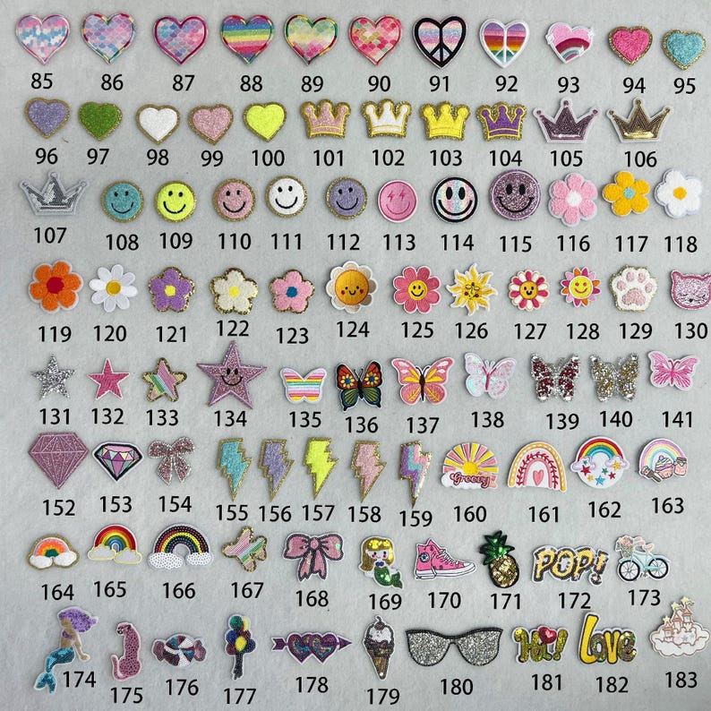 May include: A collection of 183 iron-on patches in various colors, shapes, and designs. The patches feature hearts, stars, crowns, butterflies, rainbows, and more.