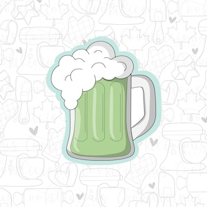 May include: A green beer mug with white foam on top. The mug has a handle and is outlined in black. The background is a white pattern of various baking tools and shapes.